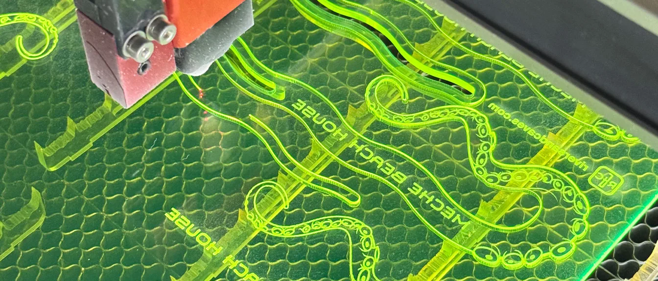 Laser Engraving vs Injection Molding. Laser engraving a custom drink stirrer of an octopus tentacle in fluorescent green acrylic.